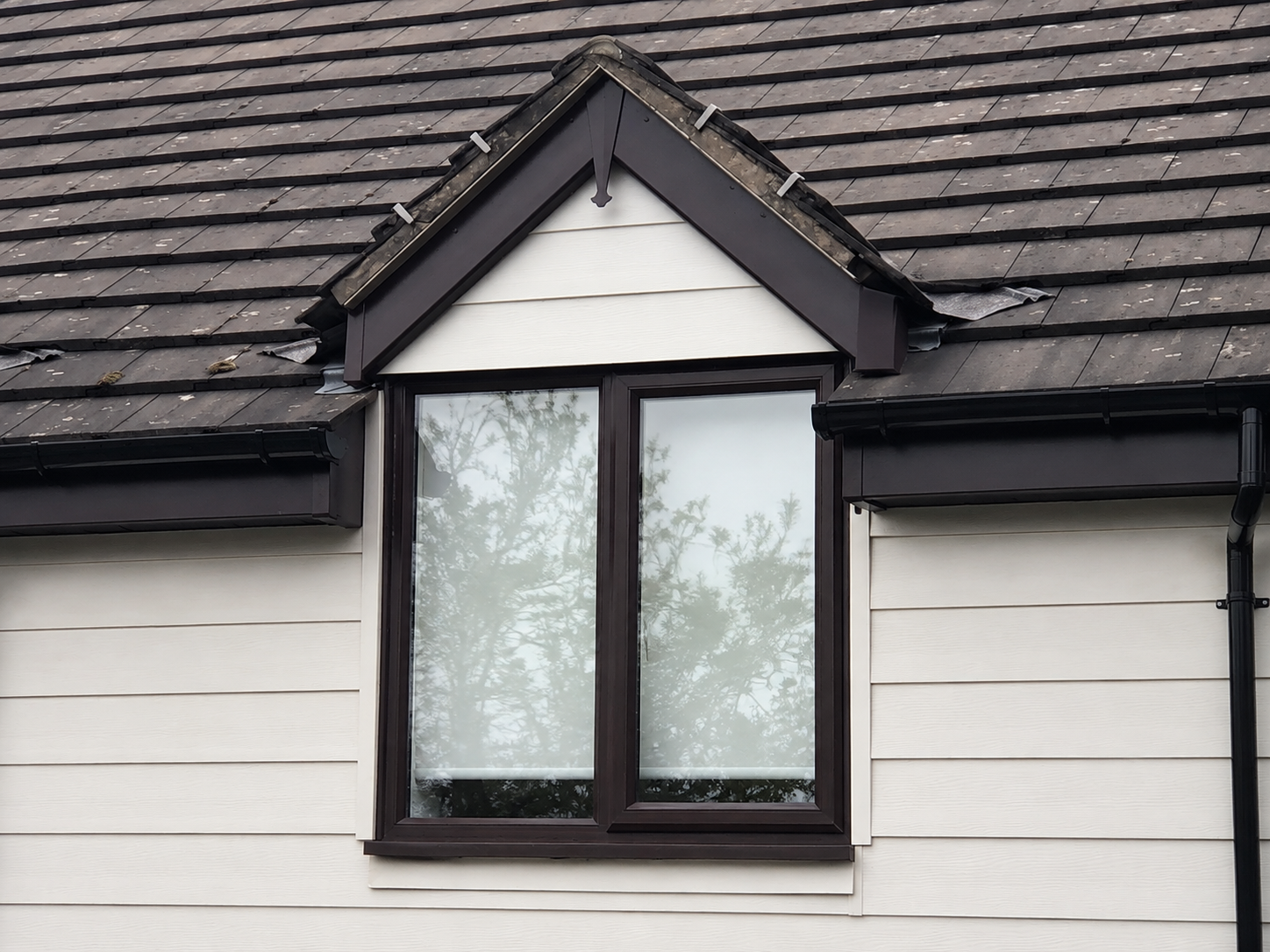 Finished dormer with white cladding and brown box ends