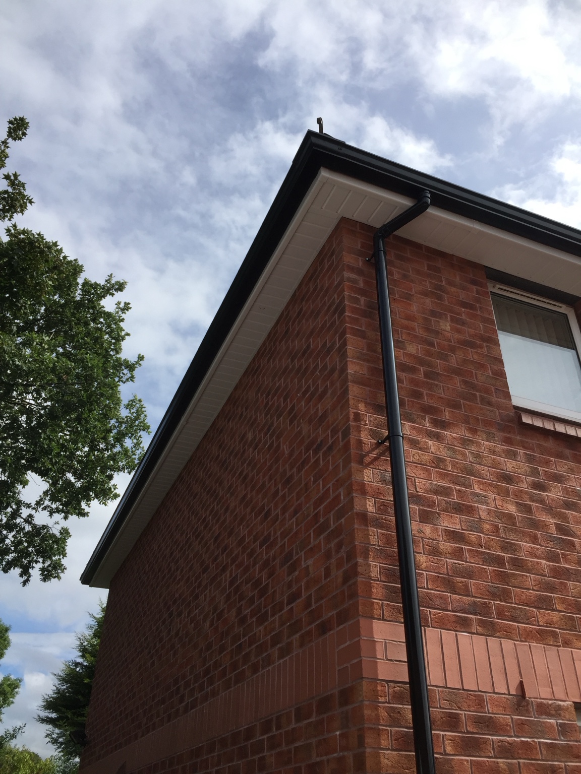 Close-up of completed seamless gutter and downpipe